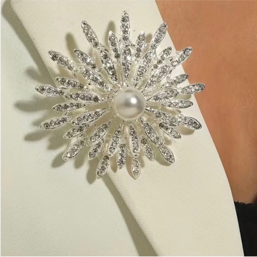 New silver-toned sunburst brooch clear rhinestones and a central faux pearl